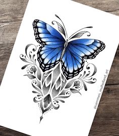 a blue butterfly tattoo on a white paper