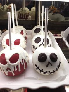 three decorated chocolate covered donuts sitting on top of a white platter with forks sticking out of them