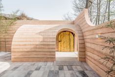 an entrance to a building made out of wood and stone with a wooden door in the center