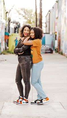 two women standing next to each other on the street