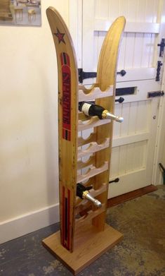 a wine rack made out of surfboards in a room with a door and white walls