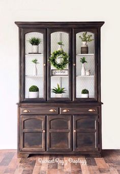 an old china cabinet is decorated with plants and wreaths