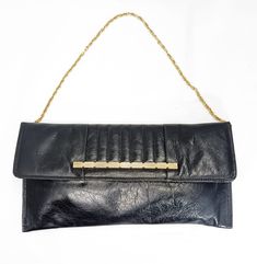 This original Pochette model bag from the 70s is beautiful and perfect. Made of very soft genuine leather, it has a decorative golden metal pattern on the flap and a golden metal shoulder chain inside. The interior is made of black suede and has a small zip pocket. Made in Italy, perfect for informal or formal looks, ceremonies, clubs, parties or work! Excellent conditions. Measures: Width 35 cm Height 18cm Thickness 1cm Shoulder strap 70 cm Metal Pattern, Shoulder Chain, Evening Clutch Bag, Evening Clutch, Vintage Shop, The 70s, Clutch Handbag, Vintage 70s, Black Suede