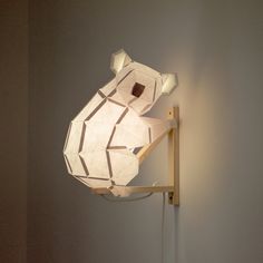 a lamp that is on the wall next to a light fixture with a bear design