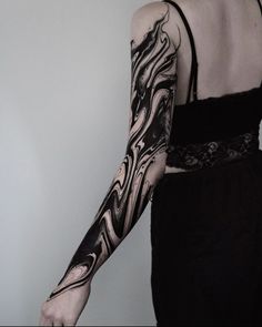 a woman with black and white tattoos on her arm