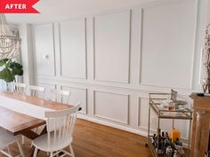 a dining room table and chairs in front of a fireplace with white paneling on the walls