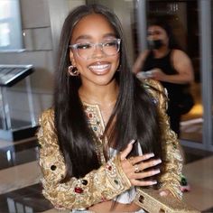 a woman with long hair and glasses smiling