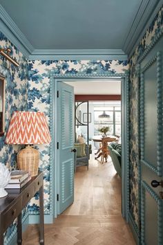 the hallway is decorated with blue and white wallpaper, along with an ornate lamp