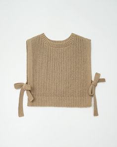 a knitted sweater with a bow on the front and back, tied at the waist