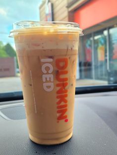 a drink sitting on the dashboard of a car