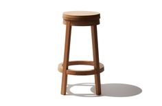 a wooden stool sitting on top of a white floor next to a shadowless wall