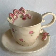 a cup and saucer with pink flowers on it