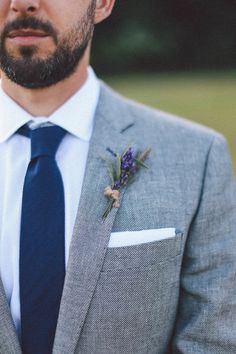 a man wearing a suit and tie with a boutonniere on his lapel