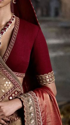 a woman wearing a red and gold sari