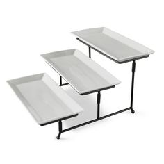 three white trays sitting on top of each other with black metal legs and bases