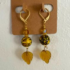 New Handmade Earrings, Hangs 2”. Acrylic Cheetah Print Bead, Sea Glass Like Leaf, Yellow Faceted Glass Bead With Aurora Borealis Coating And Gold Tone Spacers On A Hypoallergenic Gold Tone Stainless Steel Lever Back Hooks. Fun Design! Nickel-free Yellow Beaded Earrings As Gift, Nickel Free Yellow Beaded Earrings For Gift, Nickel-free Yellow Beaded Earrings For Gifts, Adjustable Yellow Earrings With Gold Beads, Yellow Earrings With Gold Beads, Nickel Free Yellow Dangle Beaded Earrings, Nickel-free Yellow Dangle Beaded Earrings, Yellow Beaded Earrings With Czech Glass, Yellow Beaded Czech Glass Earrings