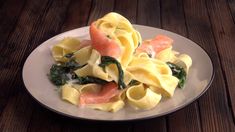 pasta with salmon and spinach on a white plate