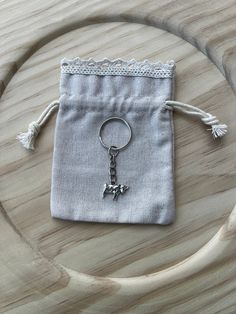 a small bag with a keychain attached to it on a wooden table next to a pair of scissors