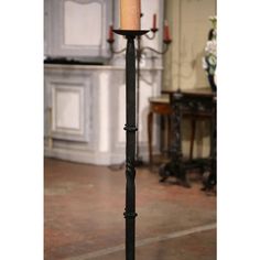 a candle that is sitting on top of a pole in the middle of a room