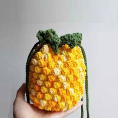 a crocheted pineapple purse is shown in yellow and green