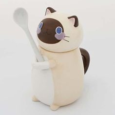 a cat figurine holding a spoon in it's mouth