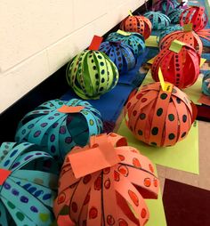 several paper pumpkins are lined up on the floor