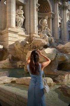 a woman standing in front of a fountain