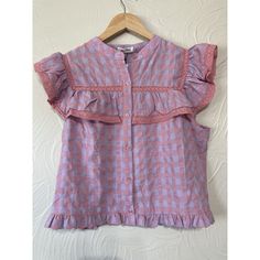 This Day + Moon Blouse In Size Large Features A Charming Gingham Pattern In Pink, With Delightful Ruffled Accents. The Short Ruffle Sleeves And Button Closure Make It A Versatile Piece For Any Occasion, Whether It Be A Party, Cocktail Event, Or Business Meeting. The Polyester Blend Material Ensures Comfort And Durability, While The Colorful And Preppy Theme Adds A Touch Of Playful Sophistication. Perfect For Adding A Pop Of Color To Any Outfit, This Basic Style Blouse Is A Must-Have For Any Ward Summer Plaid Blouse For Picnic, Summer Cottagecore Blouse With Ruffles, Cottagecore Ruffle Blouse For Summer, Spring Ruffle Blouse For Picnic, Spring Blouse With Ruffles For Picnic, Spring Ruffled Blouse For Picnic, Spring Gingham Blouse With Ruffles, Plaid Short Sleeve Tops With Ruffles, Short Sleeve Plaid Tops With Ruffles