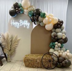 a balloon arch with hay bales and balloons