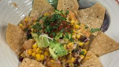 a white plate topped with nachos and corn