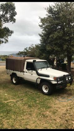 a white truck parked on top of a grass covered field