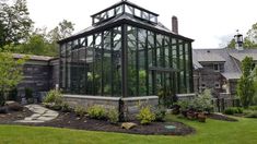 a large glass house sitting on top of a lush green field