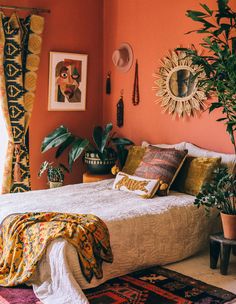 a bedroom with orange walls and plants in the corner