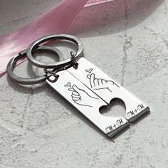 a metal keychain with a pink ribbon around it