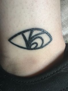 a black and white photo of a person's foot with an eye tattoo on it