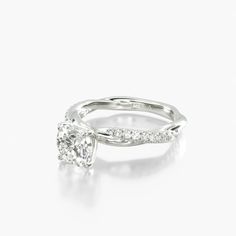 a white gold engagement ring with an oval cut diamond in the center and side stones