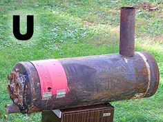 an old rusted metal mailbox sitting in the grass next to a letter u