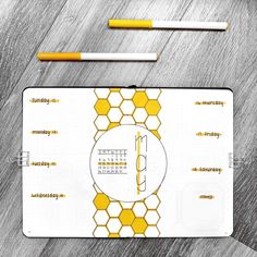 a white and yellow business card with pencils next to it