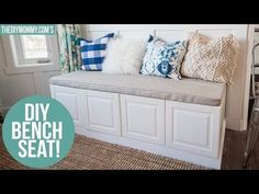 a white bench with blue and white pillows on it in front of a window that says diy bench seat