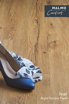 a pair of blue and white high heel shoes sitting on top of a wooden floor