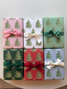 six wrapped presents with bows on them are stacked up in the shape of christmas trees