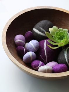 a wooden bowl filled with purple and green rocks