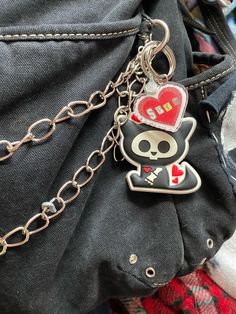 a black and white cat with a red heart on it's head sitting in a pocket