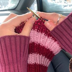 a woman is knitting in her car with a crochet hook on the handle