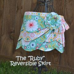 the ruffled reversible skirt is on display in front of a wooden fence