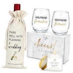 two wine glasses and a gift bag with the words cheers to a wedding printed on it