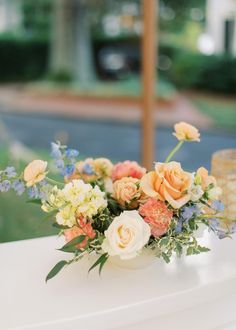 an arrangement of flowers on a white table