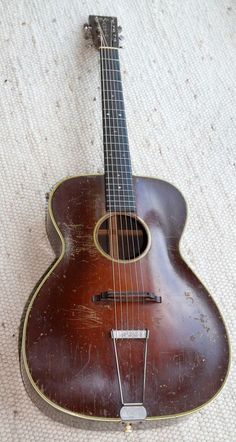 an old guitar is laying on the floor