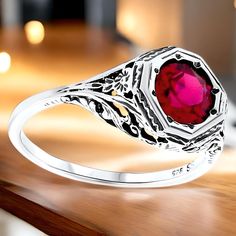 Introducing our stunning Vintage Estate 2.00 Carat Vivid Red Lab-Created Ruby Solitaire Filigree Ring--a true statement piece that combines elegance and artistry. This exquisite ring features a high-quality 6.5 mm lab-created ruby, beautifully set in a 925 solid sterling silver band adorned with delicate floral designs. The top of the ring measures 3/8 inches in length, making it a perfect fit for those who appreciate subtle yet eye-catching jewelry. The vivid red ruby symbolizes love and passion, making it an ideal choice for engagements, anniversaries, or simply to elevate your jewelry collection. To care for your vintage ring, we recommend gently wiping it with a soft, dry cloth after each wear to maintain its shine. Avoid exposing it to harsh chemicals or abrasive surfaces to prevent d Red Ruby Filigree Ring For Wedding, Classic Silver Ruby Ring For Valentine's Day, Classic Round Ruby Ring For Valentine's Day, Red Victorian Filigree Ring For Anniversary, Anniversary Ruby Ring With Intricate Design, Heirloom Red Filigree Ring, Red Ruby Filigree Ring, Red Filigree Jewelry For Anniversary, Wedding Ruby Ring With Intricate Design