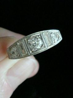 an old diamond ring is being held in someone's hand